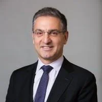 A headshot of Spiro Pappas in a dark suit and tie.